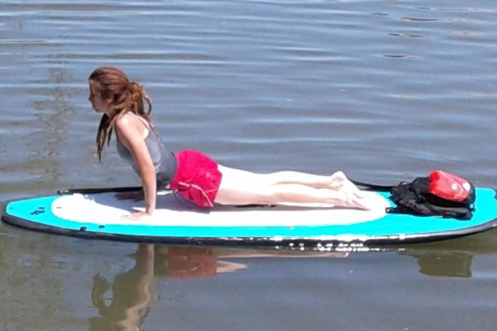 A woman performing yoga on a SUP